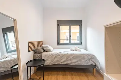a bedroom with a bed with a window and a chair at Apartamento reformado de 3 habitaciones en Sagrada Familia in Barcelona