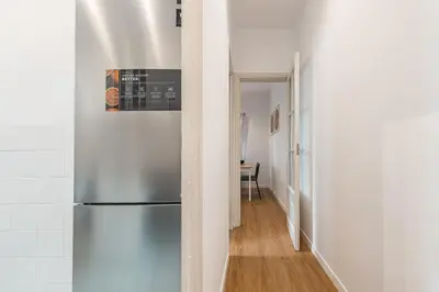 a kitchen with a stainless steel refrigerator in a hallway at Apartamento reformado de 3 habitaciones en Sagrada Familia in Barcelona
