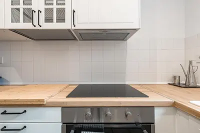 a kitchen with white cabinets and a stove top oven at Apartamento reformado de 3 habitaciones en Sagrada Familia in Barcelona