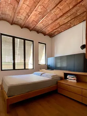 a bedroom with a large bed with a wooden ceiling at Spacious and cozy apartment in Barcelona