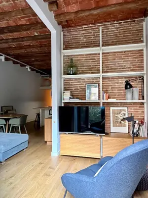 a living room with a tv and a blue couch at Spacious and cozy apartment in Barcelona