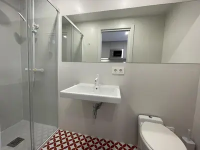 a bathroom with a sink and a toilet and a mirror at NEW 2-bedroom 2-bath, 5 min walk Metro L1-FIRA BCN in Hospitalet de Llobregat
