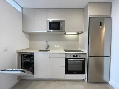 a kitchen with white cabinets and a stainless steel refrigerator at NEW 2-bedroom 2-bath, 5 min walk Metro L1-FIRA BCN in Hospitalet de Llobregat