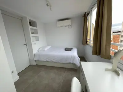 a small white room with a bed and a window at NEW 2-bedroom 2-bath, 5 min walk Metro L1-FIRA BCN in Hospitalet de Llobregat