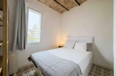 a white bed in a bedroom with a window at Apartment in BCN 2-1 in Hospitalet de Llobregat