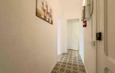 a hallway with a tile floor and a white wall at Apartment in BCN 2-1 in Hospitalet de Llobregat