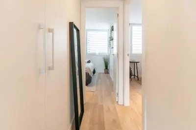 a hallway with white walls and a room with a bed at MODERN PENTHOUSE WITH TERRACE ON GRAN VIA DE CARLES III Andorra in Barcelona