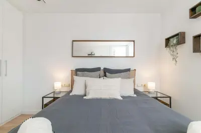 a bedroom with a large bed with two lamps at MODERN PENTHOUSE WITH TERRACE ON GRAN VIA DE CARLES III Andorra in Barcelona