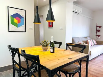 a dining room table with a bottle of wine on it at Apartment Goya in Vilanova i la Geltrú