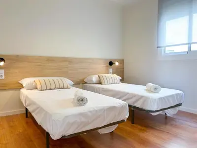 two beds in a room with white sheets at Apartment Goya in Vilanova i la Geltrú
