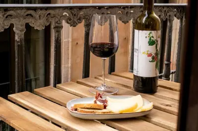 a glass of wine and a plate of bread and a bottle of wine at BOLIVIA. NEWLY RENOVATED FULL APARTMENT WITH BRIGHT TERRACE in Barcelona