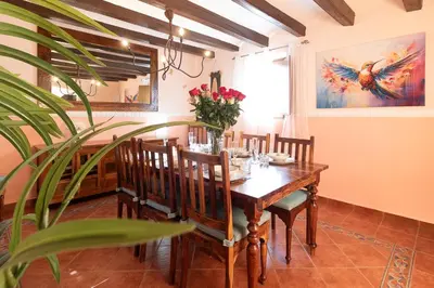 a dining room with a table with chairs and a plant at Masía con encanto para parar y desconectar in Castellví de la Marca