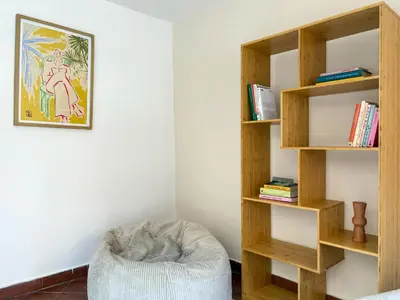 a room with a book shelf and a chair at Stay Unique Sarrià–Sant Gervasi terraza privada in Barcelona