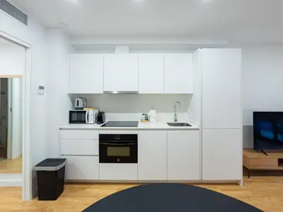 a white kitchen with a sink and a microwave at Stay U-nique Apartments Barcelona Albeniz in El Arrabal
