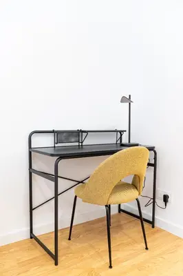 a black desk with a yellow chair and a table at Stay U-nique Apartments Barcelona Albeniz in El Arrabal