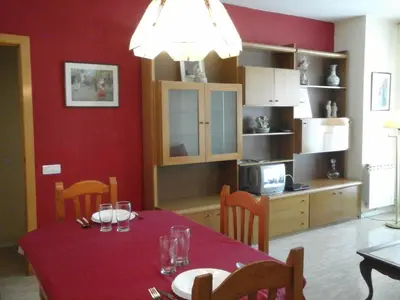 a dining room with a table and a kitchen at Apartament Fira in Hospitalet de Llobregat