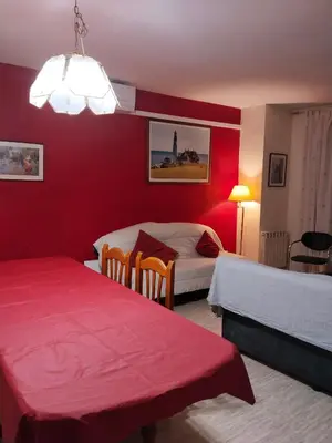 a hotel room with two beds and a red wall at Apartament Fira in Hospitalet de Llobregat