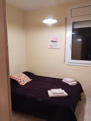 a bedroom with a bed with two towels on it at Apartament Fira in Hospitalet de Llobregat