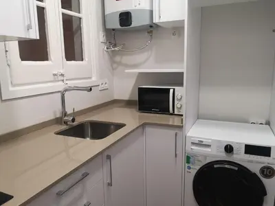 a white kitchen with a sink and a microwave at ApartEasy mid-term ONLY for VACATIONS stays, BORRELL in Barcelona