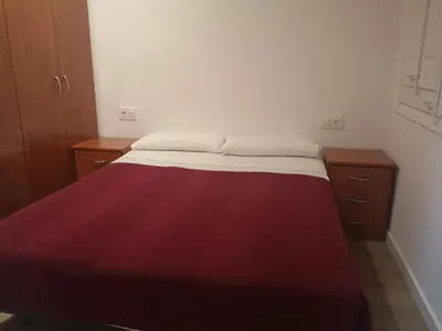 a bed in a room with a red blanket on it at ApartEasy mid-term ONLY for VACATIONS stays, BORRELL in Barcelona