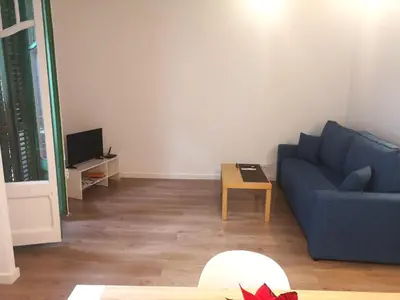 a living room with a blue couch and a table at ApartEasy mid-term ONLY for VACATIONS stays, BORRELL in Barcelona