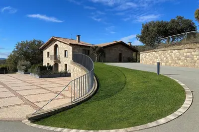 a building with a fence in front of a yard at Villa Mas Summit in Collsuspina