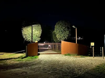 a gate with two trees in front of a fence at night at Villa Mas Summit in Collsuspina
