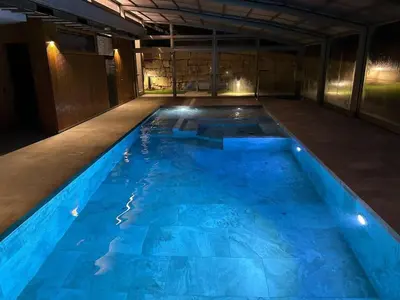a large blue swimming pool in a building at Villa Mas Summit in Collsuspina