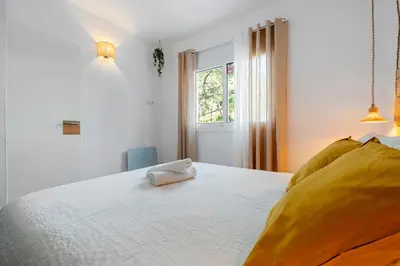 a bedroom with a white bed with a towel on it at Hauzify I Casa Olivella A in Olivella
