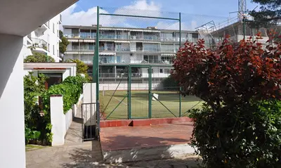 a tennis court in front of a building at Apartamento Mallorca, muy cerca de la playa in Sitges