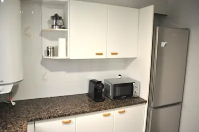 a kitchen with white cabinets and a microwave on a counter at Santa Barbara, in downtown Sitges in Sitges
