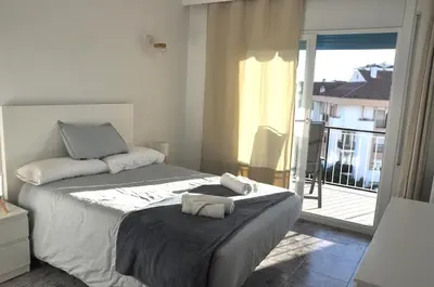 a bedroom with a large bed with a balcony at Santa Barbara, in downtown Sitges in Sitges