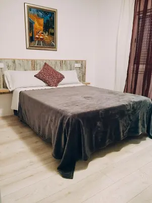 a bed with a brown blanket on it in a room at Apartamento 2º centrico con Parking en Calella,Barcelona in Calella
