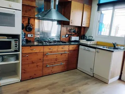 a kitchen with wooden cabinets and a stove top oven at Apart 1º & Spa and Parking in Calella, Barcelona in Calella