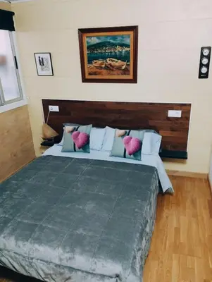 a bedroom with a large bed with a wooden headboard at Apart 1º & Spa and Parking in Calella, Barcelona in Calella