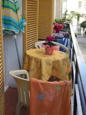 a table with chairs and a table with flowers on it at Apartamentos Montserrat in Sitges
