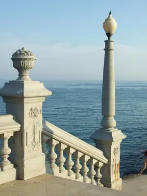 a white railing with a pole next to the ocean at Apartamentos Montserrat in Sitges