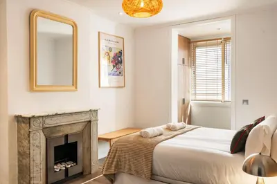 a bedroom with a bed and a fireplace at Eixample Pedestrian Gem Balcony Bathtub AC in Barcelona