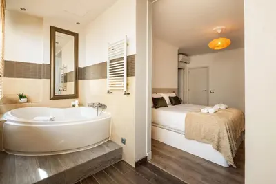 a bathroom with a tub next to a bed at Eixample Pedestrian Gem Balcony Bathtub AC in Barcelona