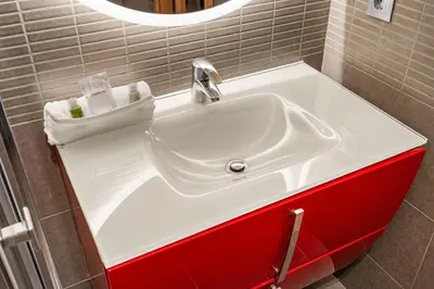 a bathroom with a white sink and red cabinets at Eixample Pedestrian Gem Balcony Bathtub AC in Barcelona