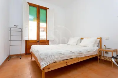 a bedroom with a bed with white sheets and a window at Apartamento céntrico en Poble Sec in Barcelona