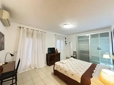 a bedroom with a bed and a desk and a television at Rooms Consell de Cent in Barcelona