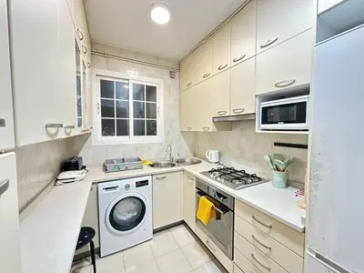 a kitchen with a washing machine and a sink at Rooms Consell de Cent in Barcelona