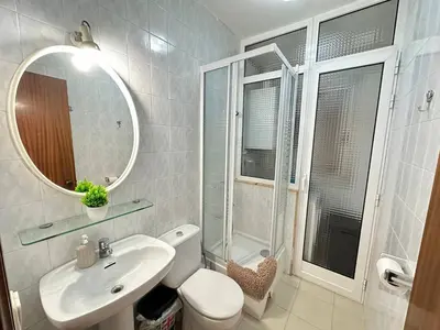 a bathroom with a sink and a toilet and a mirror at Rooms Consell de Cent in Barcelona