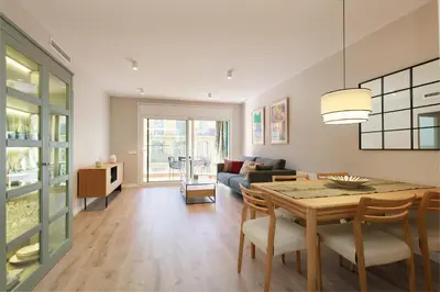 a living room with a table and a couch at ApartEasy mid-term ONLY for VACATIONS stays, EIXAMPLE CENTER in Barcelona