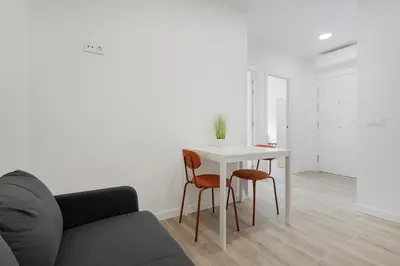 a living room with a table and two chairs at Apartahotel Sant Marti Suites in San Martín Sarroca
