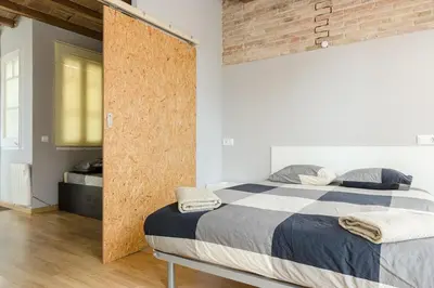 a bedroom with a bed and a brick wall at ApartEasy mid-term ONLY for VACATIONS stays, ATIC GRACIA in Barcelona