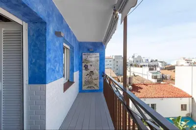 a balcony with blue walls and a window at Little Dream Apartment Sitges in Sitges
