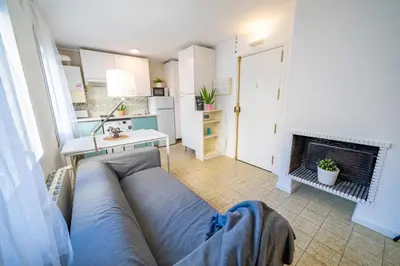a living room with a blue couch and a bed at HomeHolidaysRentals Olimpia - Costa Barcelona in Pineda de Mar