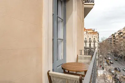 a balcony with two chairs and a table and a window at Lovely Apartment with Balcony in Sagrada Familia in Barcelona